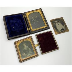 A Victorian ambrotype photograph in gilt surround and Vulcanite type Union case, decorated in low relief to front and verso with a female figure upon horseback, H12.5cm, together with a leather case daguerreotype, and a further loose example. (3).  