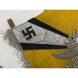 Two replica German Luftwaffe trumpet banners, one heavily silver wire embroidered with Luftwaffe eagle in a wreath, on an amber, white and black rayed background, , with silver wire tasselled border and four leather hanging loops, approx. 50 x 49cm; the other slightly larger heavily gold wire embroidered with the Luftwaffe eagle on a plain amber ground with gold wire tasselled border and two hanging loops (2)