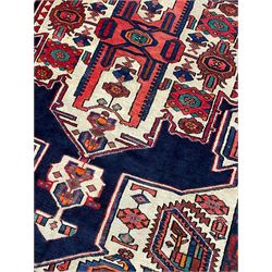 North West Persian Heriz rug, blue and ivory ground, decorated with stylised plant motifs, the border decorated with repeating geometric design 