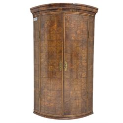 Yew wood bow front corner cupboard, projecting cornice over two doors inlaid with cubed figured end grain veneer, the interior fitted with two shelves