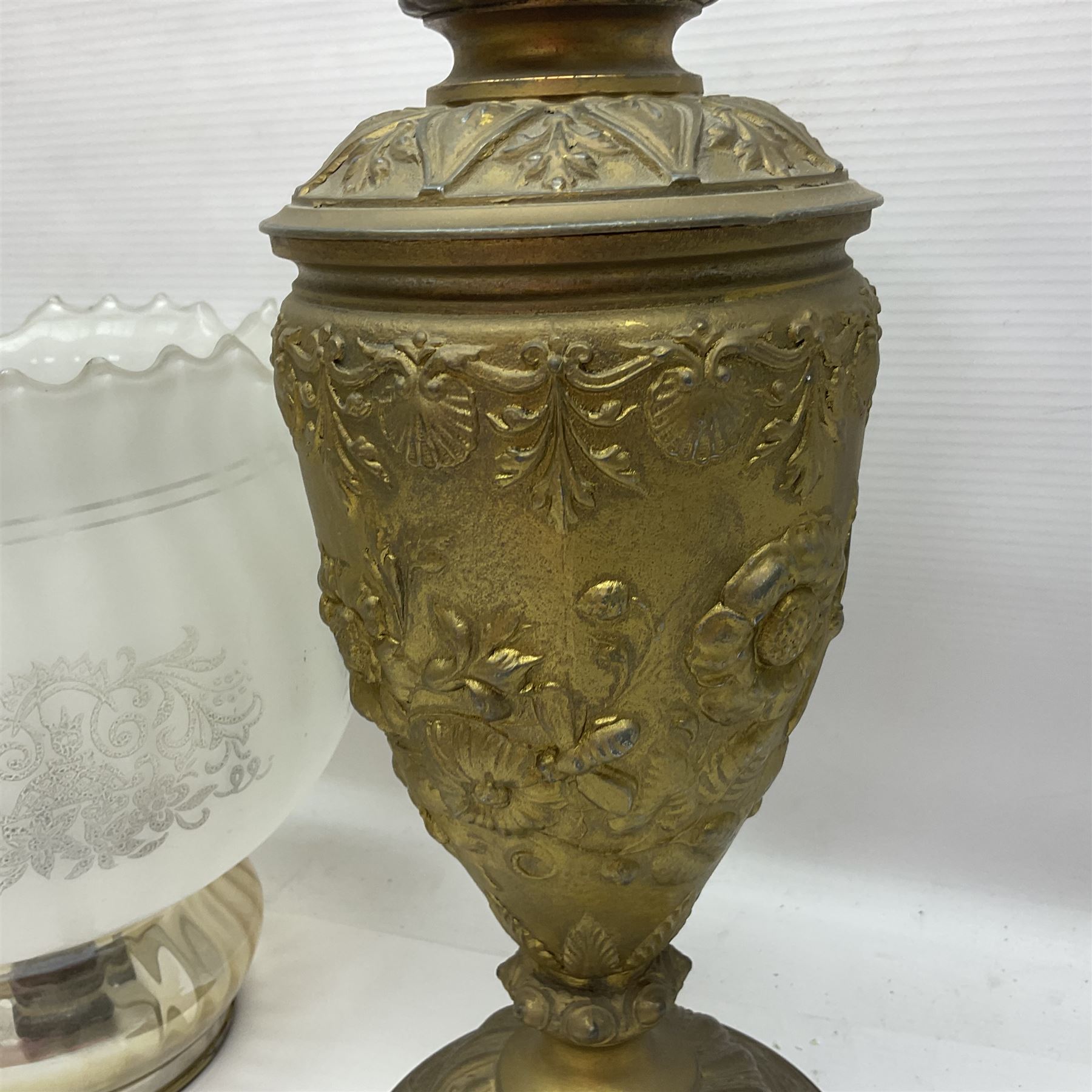 Gilt metal table lamp, heavily embossed with flowers and butterflies, with fluted frosted glass shade, H56cm