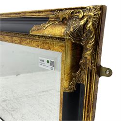 Victorian design ebonised and gilt wall mirror, the moulded rectangular frame decorated with foliate cartouches, bevelled mirror plate 