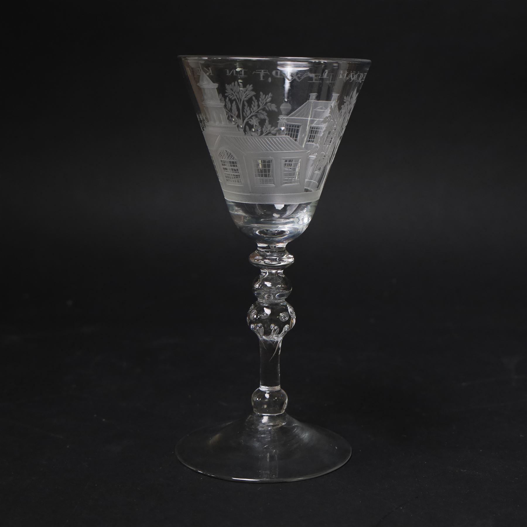 Dutch engraved Newcastle light baluster glass, circa 1760, the funnel bowl engraved with a two storey country house and church flanked by trees, beneath the inscription ‘T WELVAREN VAN LANDT ENKERK’ (The prosperity of the Country and Church), upon a multi knopped stem with beaded knop and basal knop, over conical foot, H18cm



