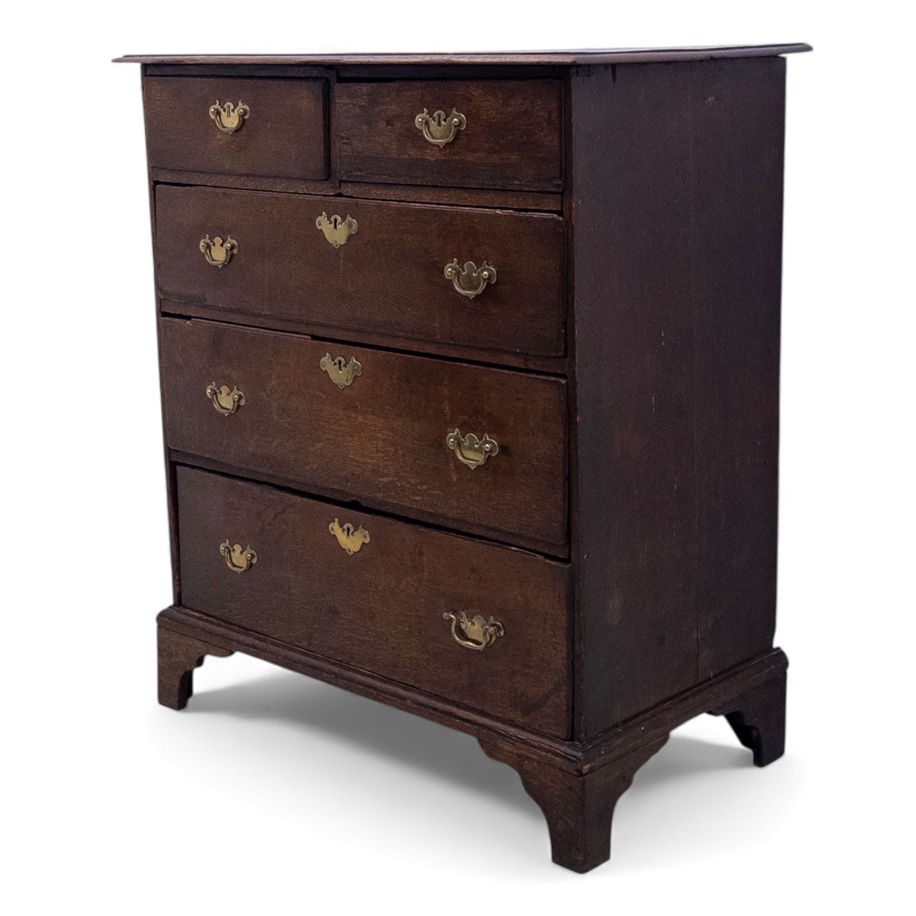 18th century oak chest, the rectangular top above an arrangement of two short over three long drawers fitted with brass batwing handles and escutcheons, raised upon shaped bracket feet