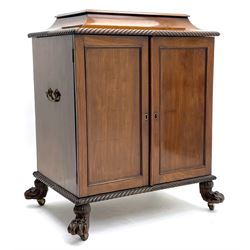 Late 19th century Irish mahogany champagne cellarette, sarcophagus top with gadroon moulded edge lifting to reveal fitted interior, over two panelled doors and cast brass carry handle to each end, gadroon moulding to bottom, raised on hairy paw feet with brass and ceramic castors