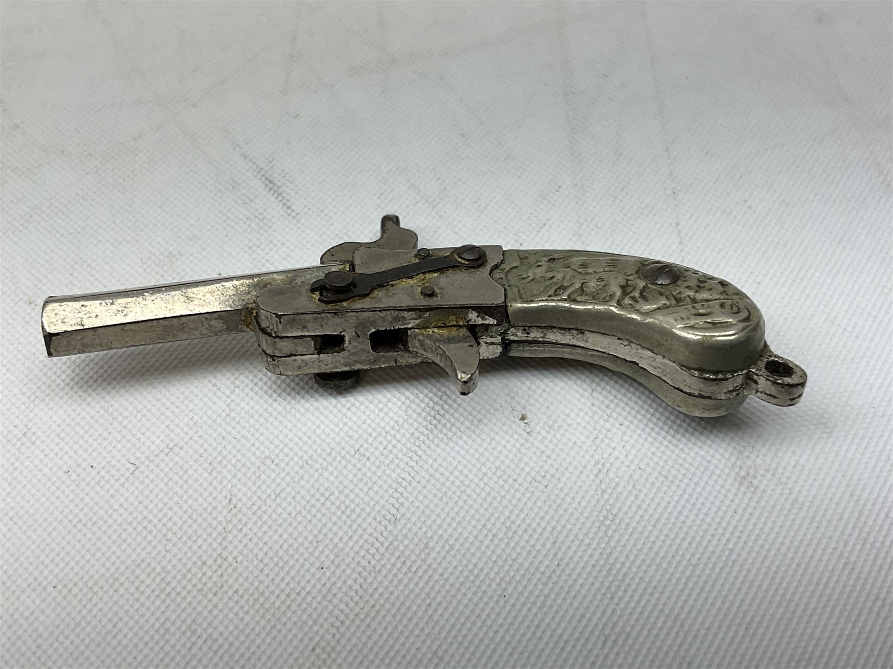 Miniature all nickel 2mm pin fire single shot pistol with engraved grip L4.5cm; together with a .925 silver half hunting cased keyless wind pocket watch inscribed 'Presented to Pte. P. Sizer By No.2 Company 1st Battalion Lincolnshire Regmt For Gallant Conduct Nr. Cork (Ireland) 31.7.20' (2)