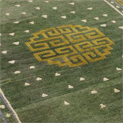 Chinese Ningxia rug, green field with central stylized shou medallion and scattered cloud motifs within key fret borders in shades of olive green, fringe ends partially detached 