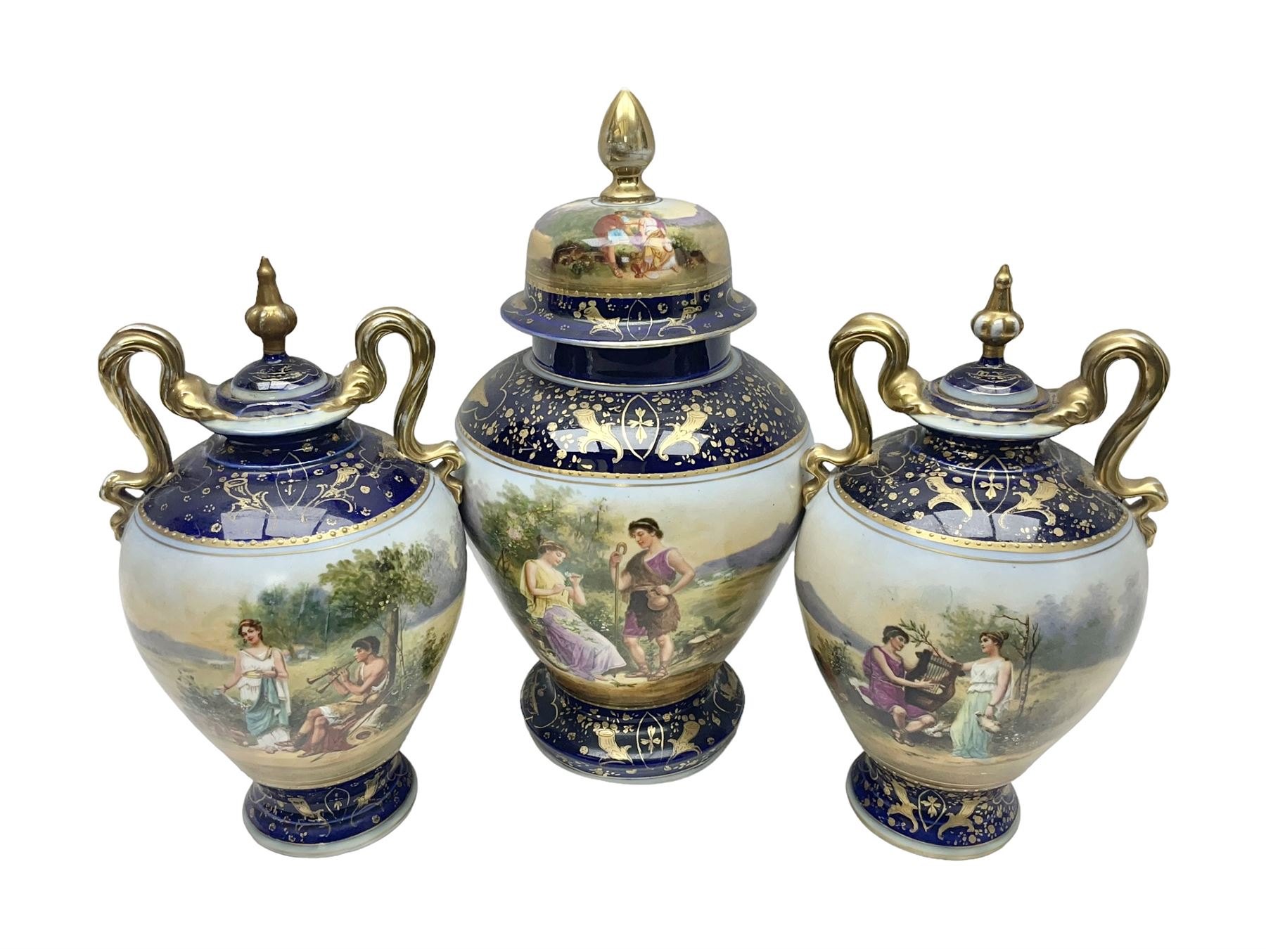 19th century Vienna style porcelain 'Musik' garniture, the central vase of baluster form with domed cover flanked by two smaller vases with twin curved gilt handles to short neck, each decorated with classical figural vignettes between blue borders heightened with gilt, H33.5cm