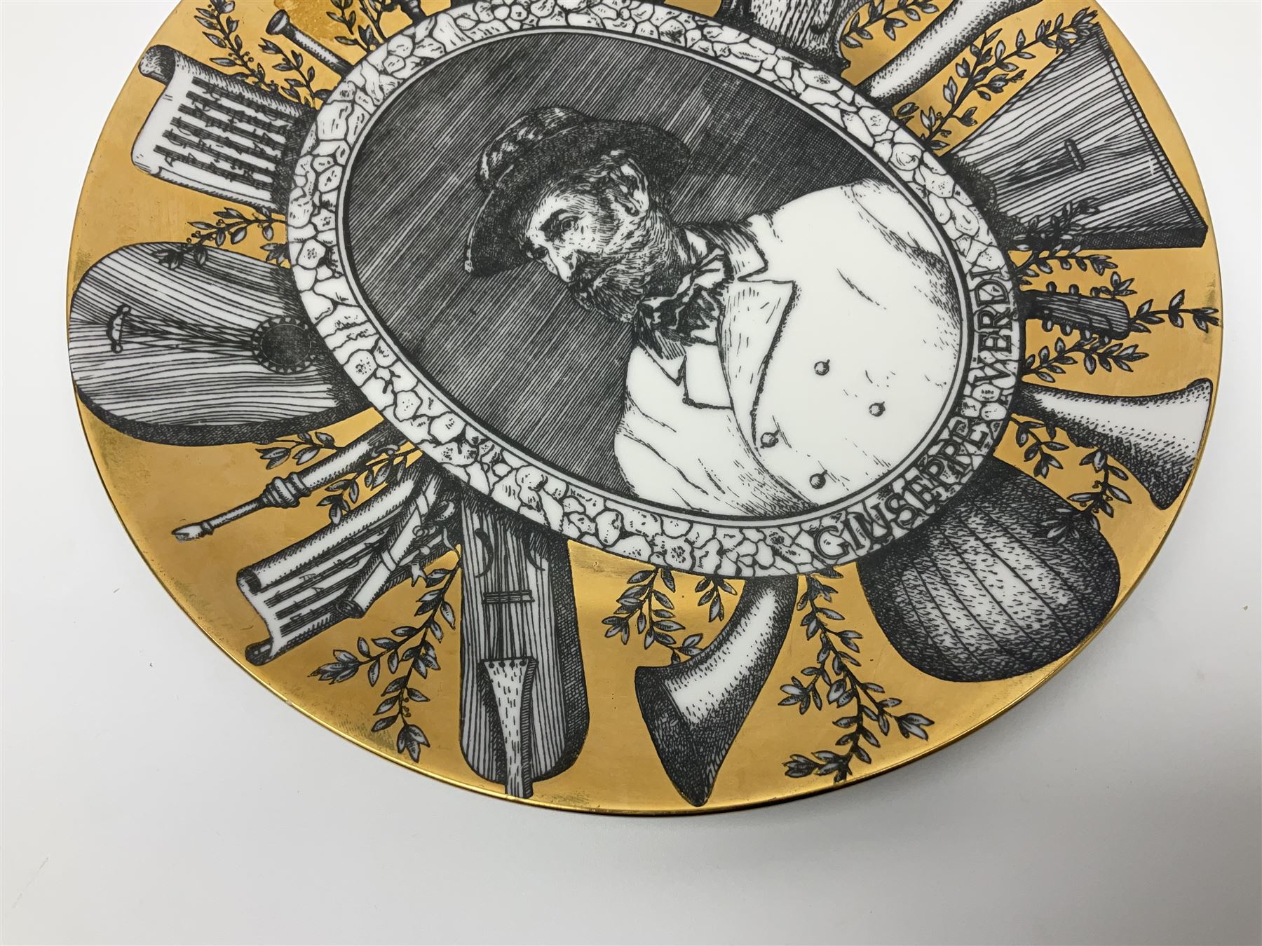 Fornasetti Grandi Maestri plate, depicting Giuseppe Verdi within a border of operatic emblems on gilt ground, with printed mark beneath, D25cm