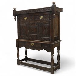 19th century and later carved oak court cupboard, the upper section with two drawers above a central cupboard door flanked by panels, lower section with single long drawer, on turned supports united by carved stretchers