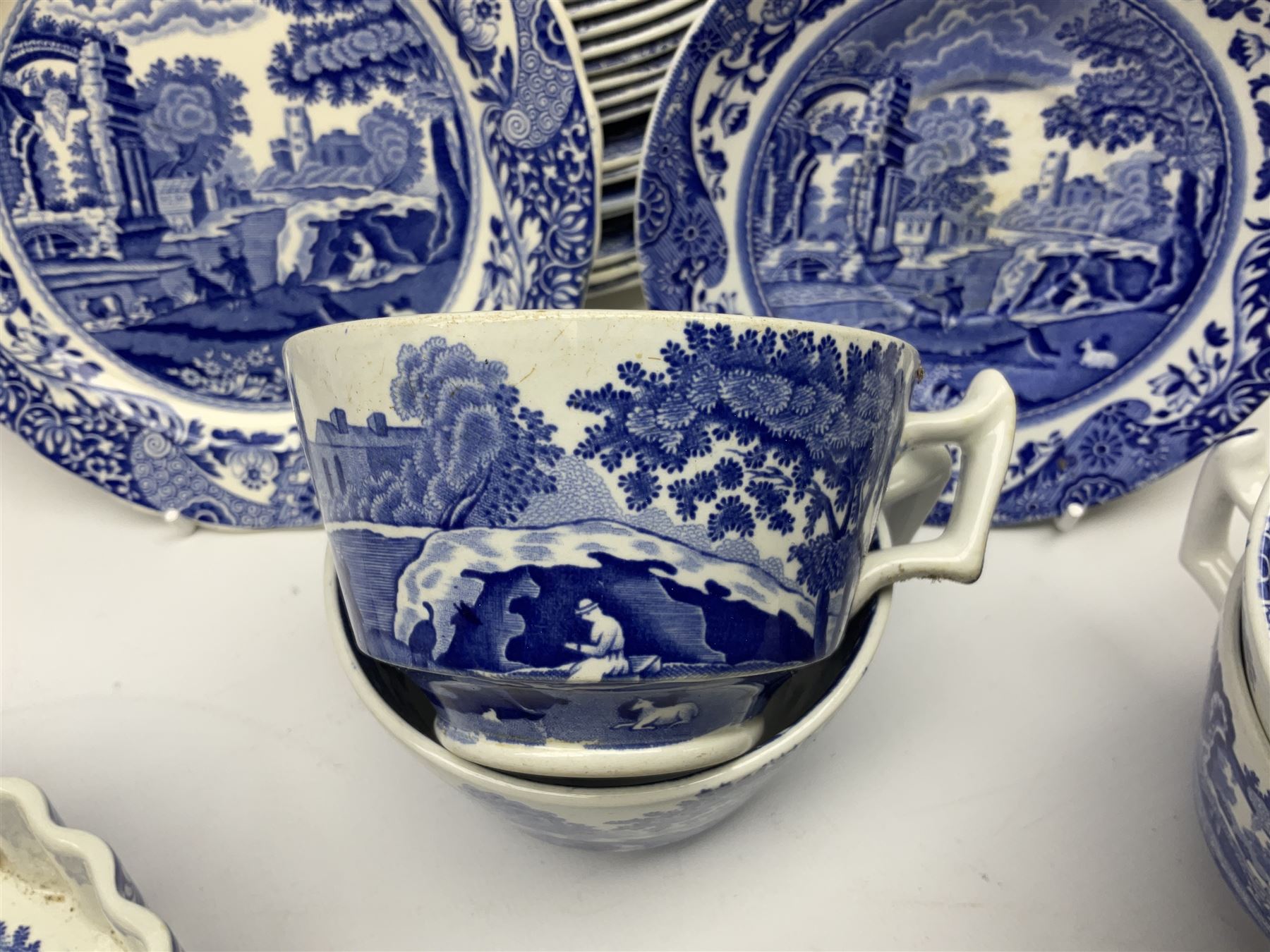 Spode blue and white Italian pattern dinner and tea wares, comprising five dinner plates, four side plates, seventeen side plates, four bowls, ten tea cups and twenty one saucers, five coffee cans and six saucers, and a flan dish, with blue and black printed marks beneath 