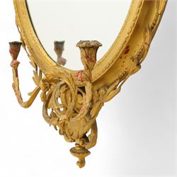 Late 19th century Louis XVI style giltwood and gesso girandole oval wall mirror, the oval frame surmounted with stylized urn finial and ribbon-tied garlands, laurel swags and rosettes, egg and dart decorated inner moulding and linked acorn outer moulding, flanked by intertwined foliate decorated candle branches 