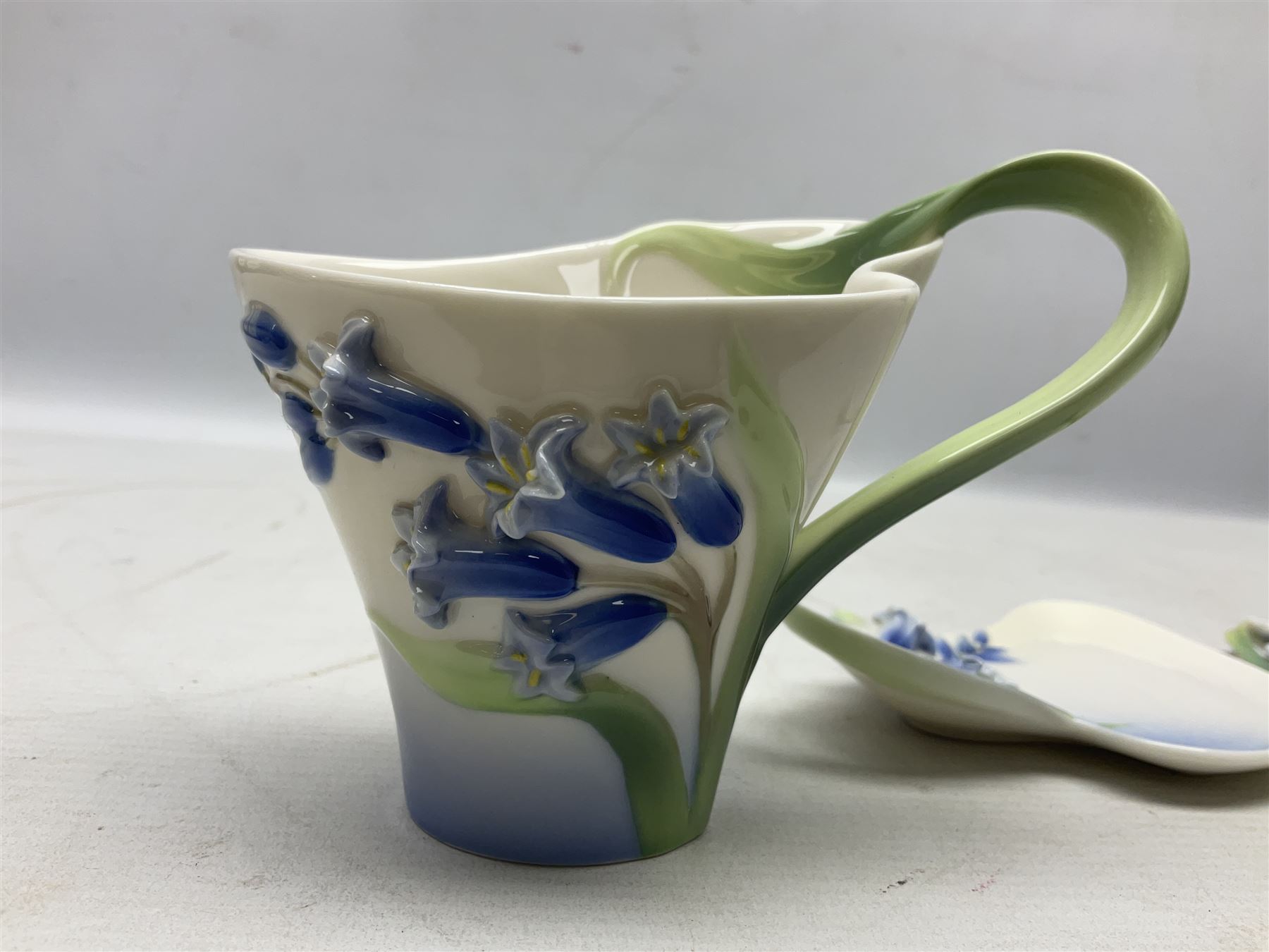 Five Franz teacups and saucers comprising Hummingbird FZ00129, Bluebell FZ00875, Dragonfly FZ00028, Butterfly XP1693 and Daisy FZ00793, together with Hummingbird spoon, all boxed (6)