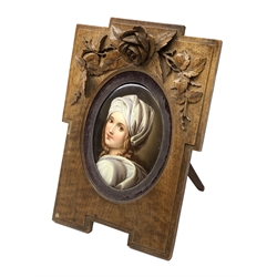 19th century KPM style oval porcelain plaque, painted with a portrait of Beatrice Cenci after Guido Reni, signed verso s.l.n?, in Continental walnut shaped frame with Rose carved crest and easel style support verso, plaque 13cm, frame H25.5cm  