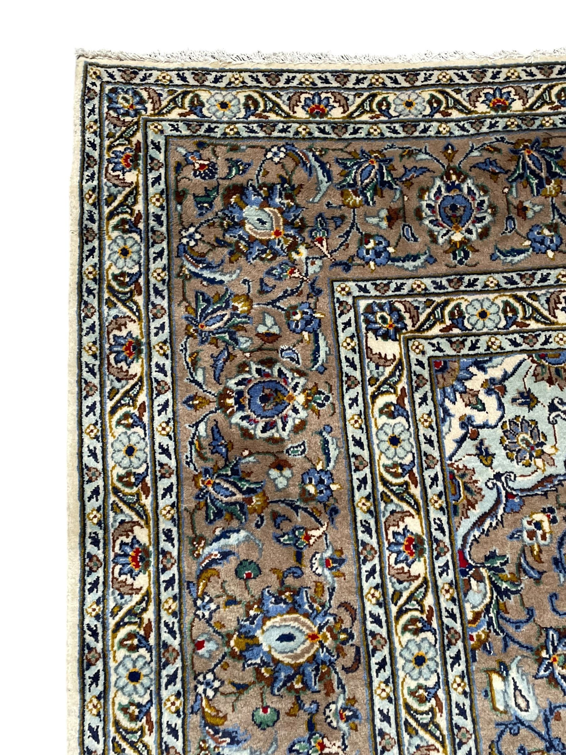 Persian Kashan ivory ground carpet, central medallion on a field of scrolling foliate branches decorated with palmettes, the border decorated with repeating stylised plant motifs, floral design guard stripes