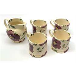Four Emma Bridgewater mugs, together with a matching jug, each decorated with purple flowers upon a cream ground, mugs H7cm, jug H10cm. 