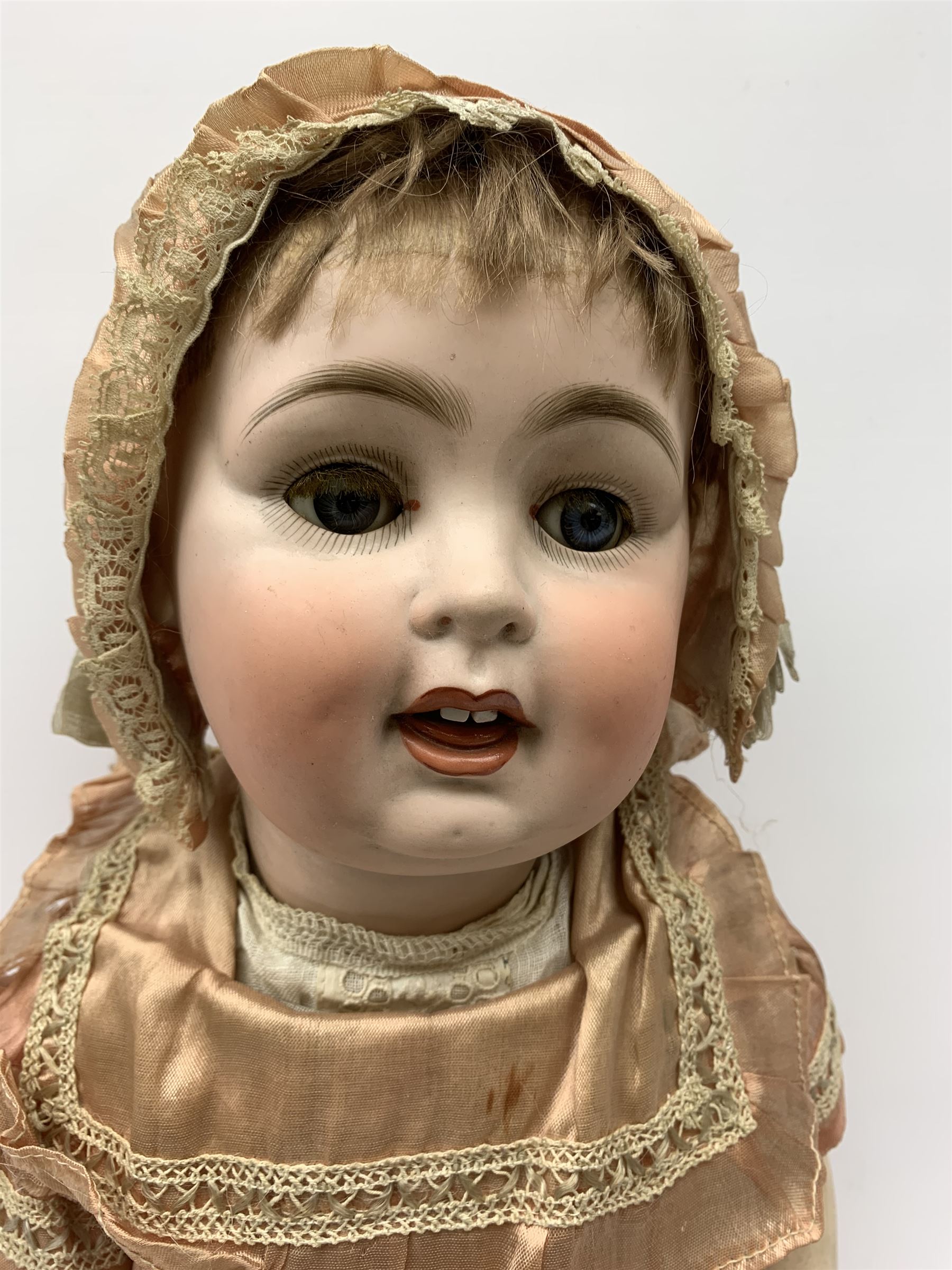 German bisque head doll with applied hair, sleeping eyes and open mouth with teeth and fixed tongue, on composition body with jointed limbs, marked 'P.M. 914 Germany 14' H65cm