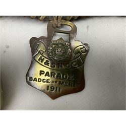 Victorian Queen Victoria record reign horse brass and H&SNCC Parade Badge of Merit 1911 horse brass, both on leather strap, together with 1924 British Empire Exhibition brass Lipton's souvenir tea caddy, strap L36cm