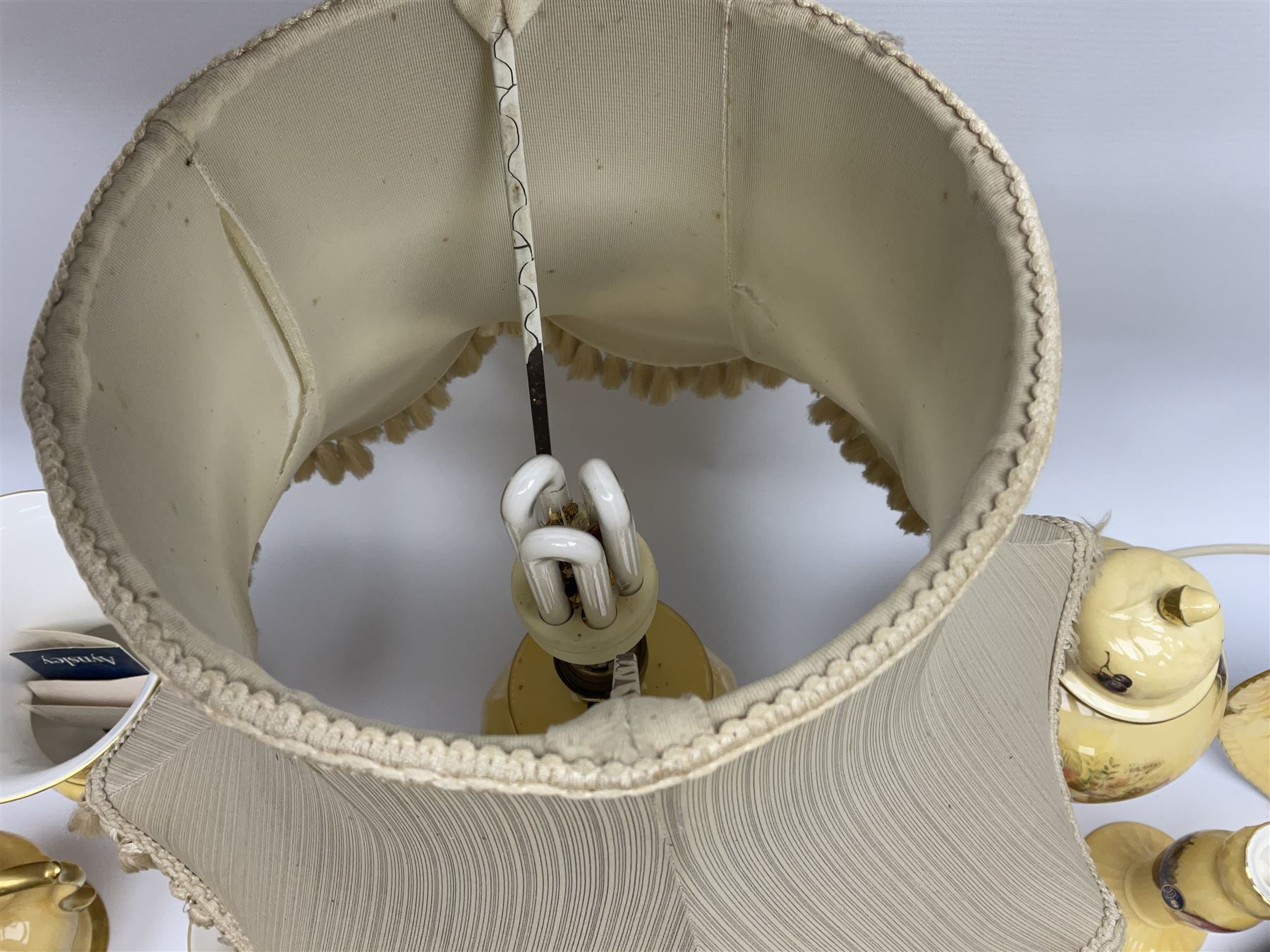 Collection of Aynsley Orchard Gold pattern wares, comprising lamp base, three jars and covers, six vases or various size and form, large jug, lidded dish, pair of cruets, pair of candlesticks, mug, two pin dishes, lobed dish, tea cup, saucer, size plate, and cake plate, and two further cups and saucers, each cup decorated with central Orchard Gold reserve to the interior against a mottled pink or green ground. 