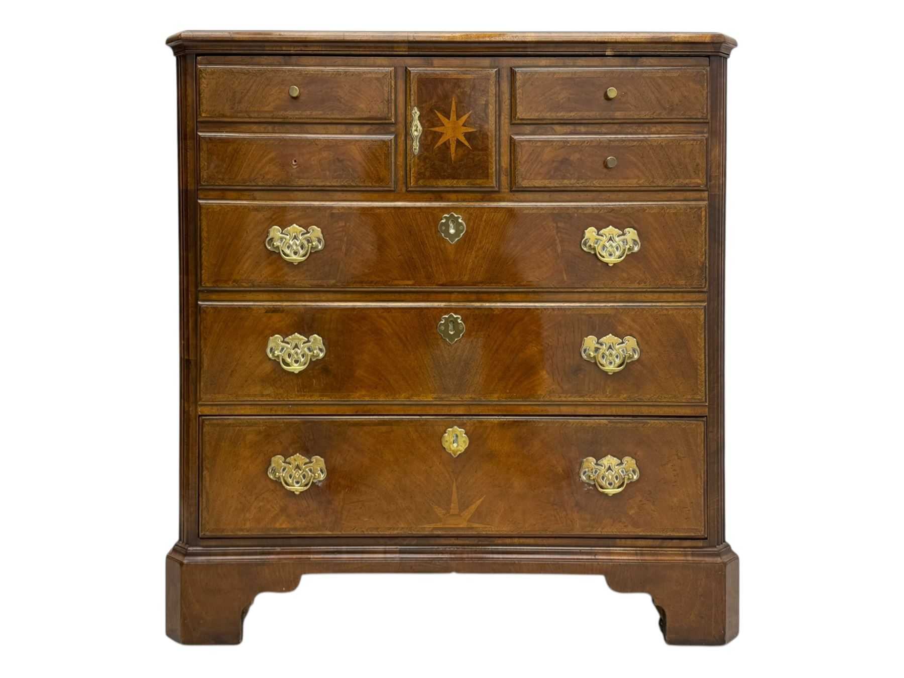 Late 20th century walnut veneered television chest in Georgian style, rectangular top over simulated drawer front with central marquetry star inlay, opening to a shelved TV compartment, lower section fitted with one long drawer, brass handles and ogee bracket feet