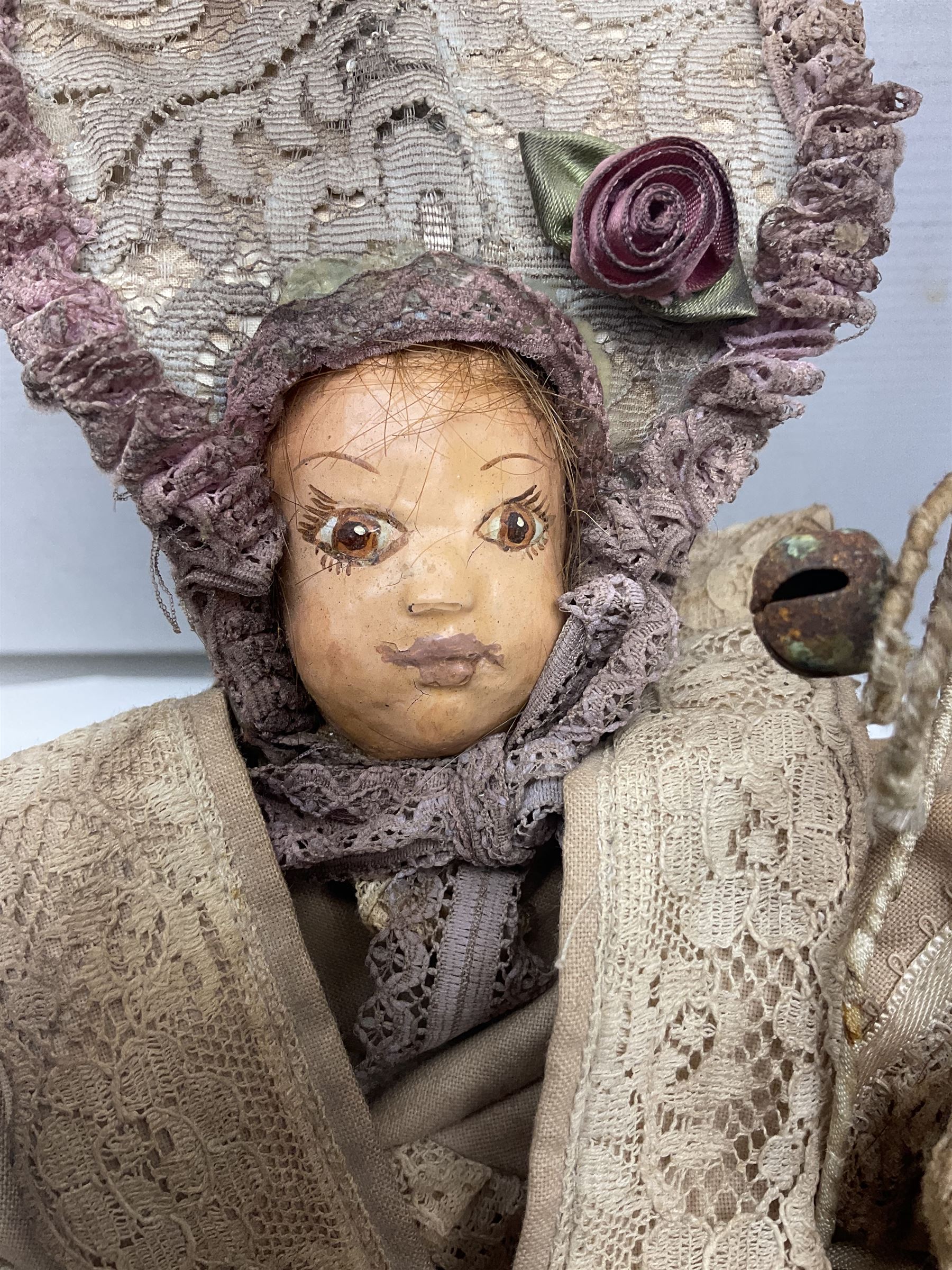 Modern reproduction automaton in the form of a baby doll in a basket clothed in Victorian style lace bloomers and frilled bonnet; clockwork action; on raised platform; with French paper label on base, 29cm wide,