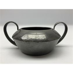 Liberty & Co Tudric pewter three piece tea service, comprising teapot with woven reed handle, twin handled open sucrier, and milk jug, each of squat form with planished finish, each impressed beneath Tudric Pewter Ware 01537 Made in England, together with a matched unmarked tray