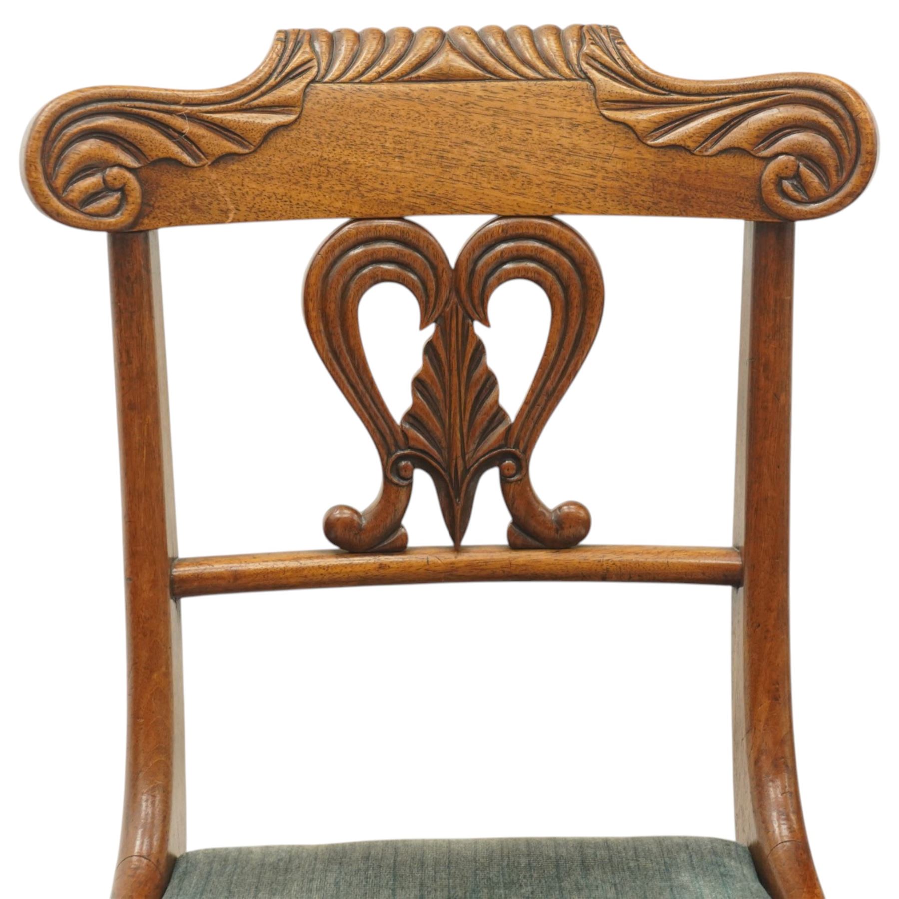 Set of eight (6+2) Regency period mahogany dining chairs, the ornately carved cresting rail of gadrooned and foliate design, over a pierced swan-neck splat with scrolling foliate carving, the carvers with scrolled arm terminals, over teal-upholstered drop-in seats, raised on Gillows-design reeded and tapering front supports, retailed by David Hick Interiors, Jersey