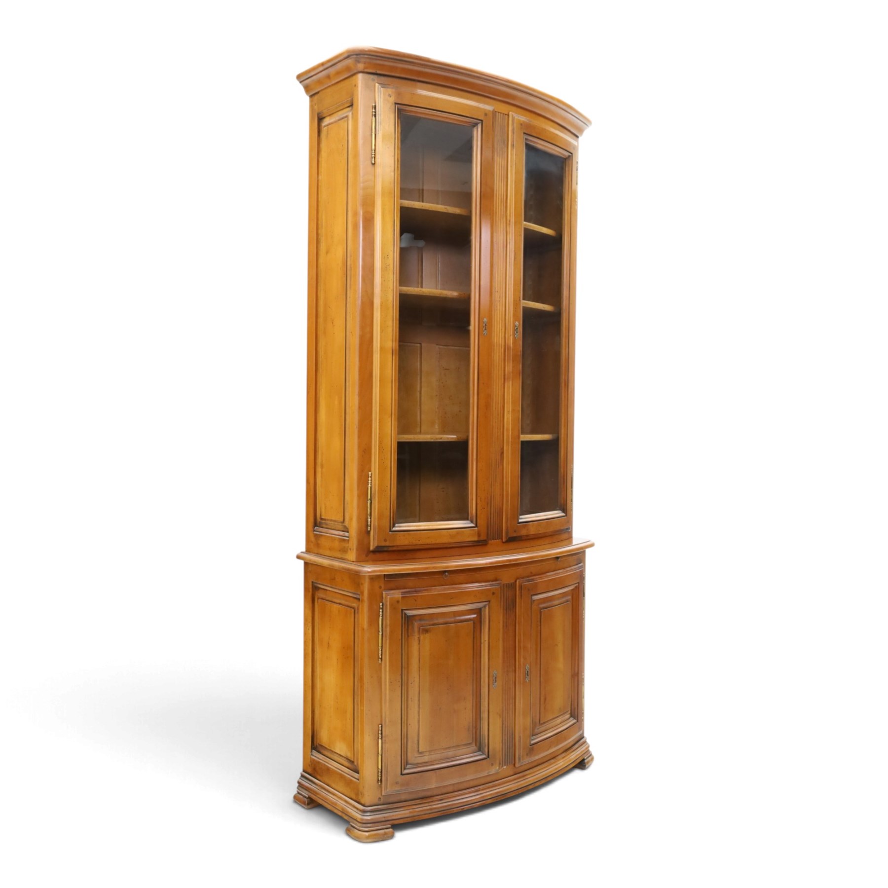 Wesley Barrell - French cherry wood bow front display cabinet, the upper section with glazed doors and three adjustable shelves, raised on cupboard base with brushing slide and further adjustable shelf, raised on a moulded plinth base with bracket feet