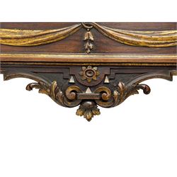 Pair of 19th century Italian walnut and parcel gilt console tables with raised mirrors - arched pediment surmounted by scrolled carving, central projecting winged putto mask over plain rectangular mirror plate, in a rectangular moulded frame with extending upper corners, decorated with flower head and foliate mounts, the table of break-front rectangular form with moulded top, the frieze decorated with linen swags and bellflowers, foliate scroll carved apron, on four tapering and stop-fluted supports carved with flower heads, break-front moulded lower platform on bracket feet 