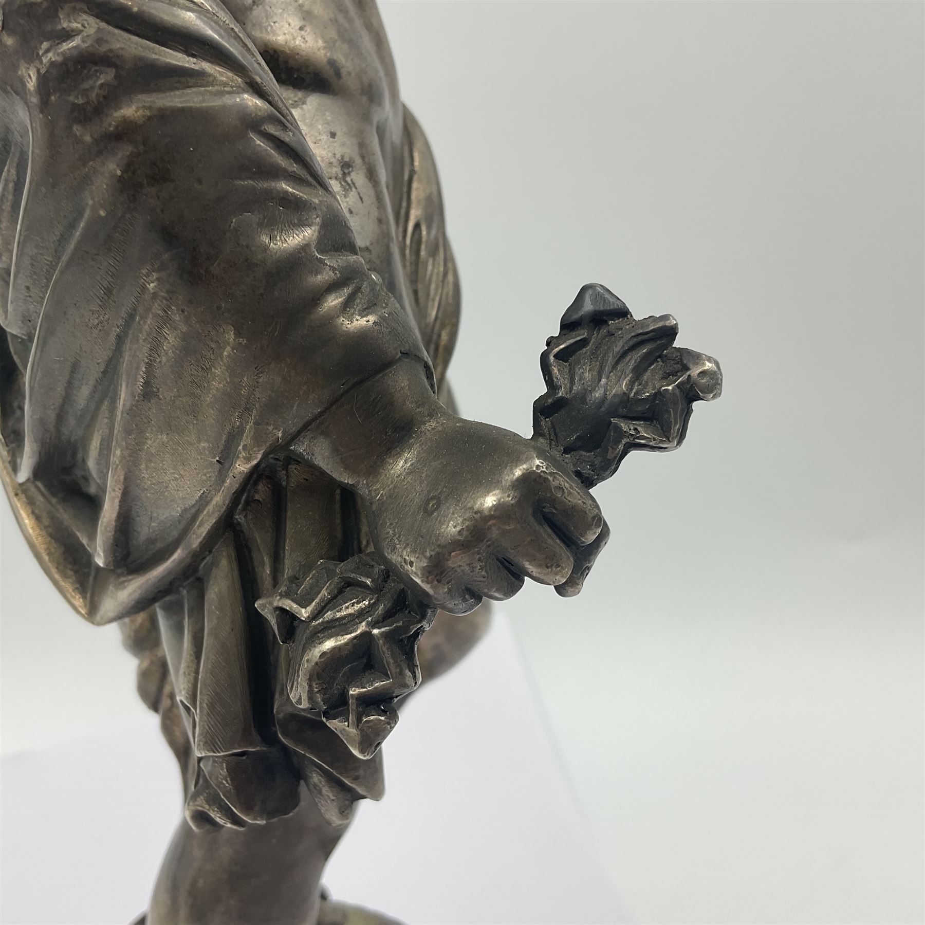 20th century silver plated figure, modelled as a classical male figure, possibly Prometheus, holding flames, one foot resting atop a small dragon, upon a circular spreading base, overall H37.5cm