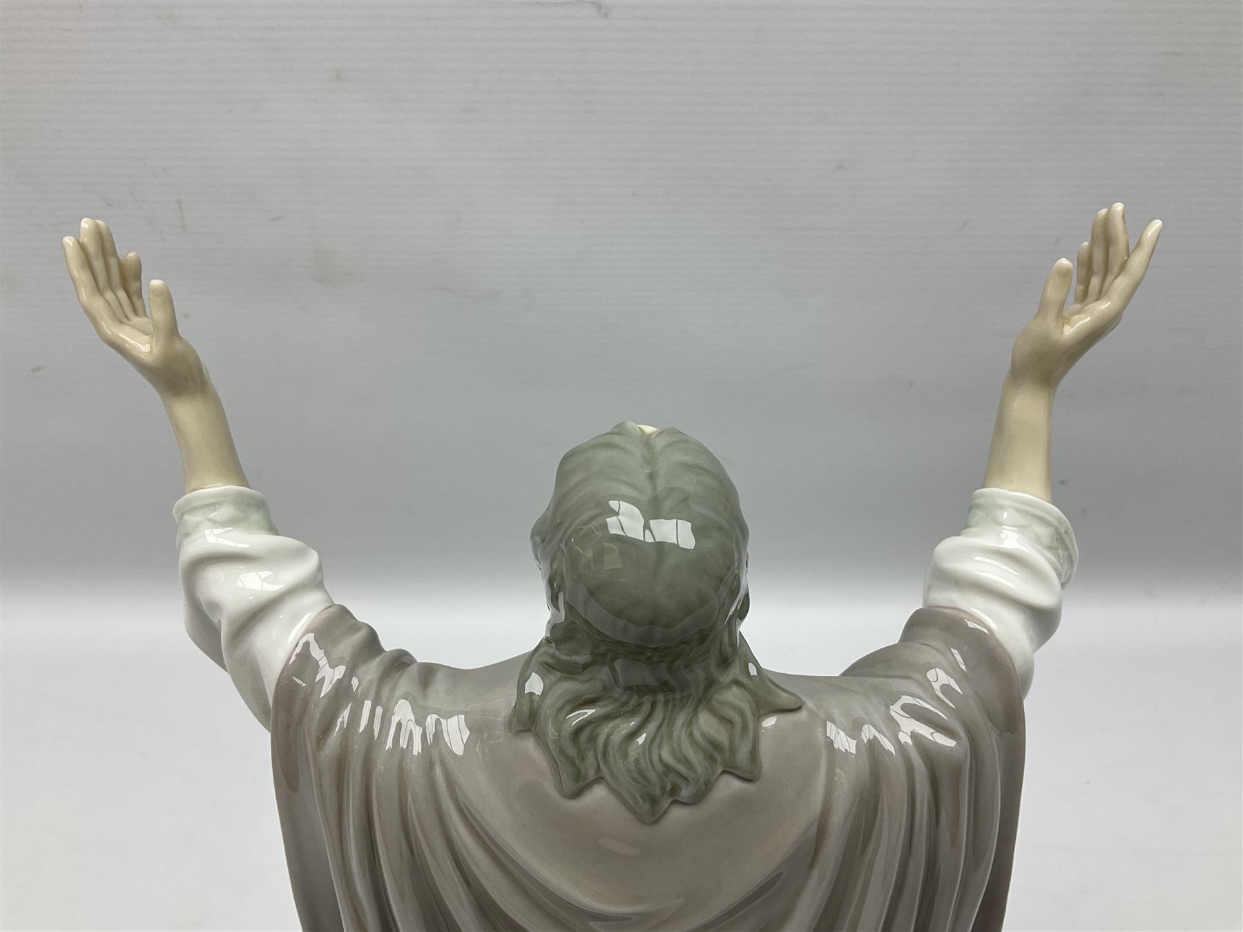 Lladro figure, The Loaves and Fishes, modelled as Jesus Christ with arms raised standing beside a basket of loaves and a basket of fish, sculpted by Salvador Furió, with original box, no 5896, year issued 1992, year retired 1997, H35cm