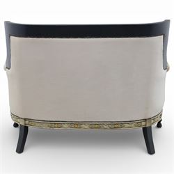20th century Louis XVI style settee, upholstered in cream fabric with buttoned back and arms, and plain seat cushions, the shaped and black painted frame with entwined foliate detail and gilt flower heads, upon column legs with bun feet