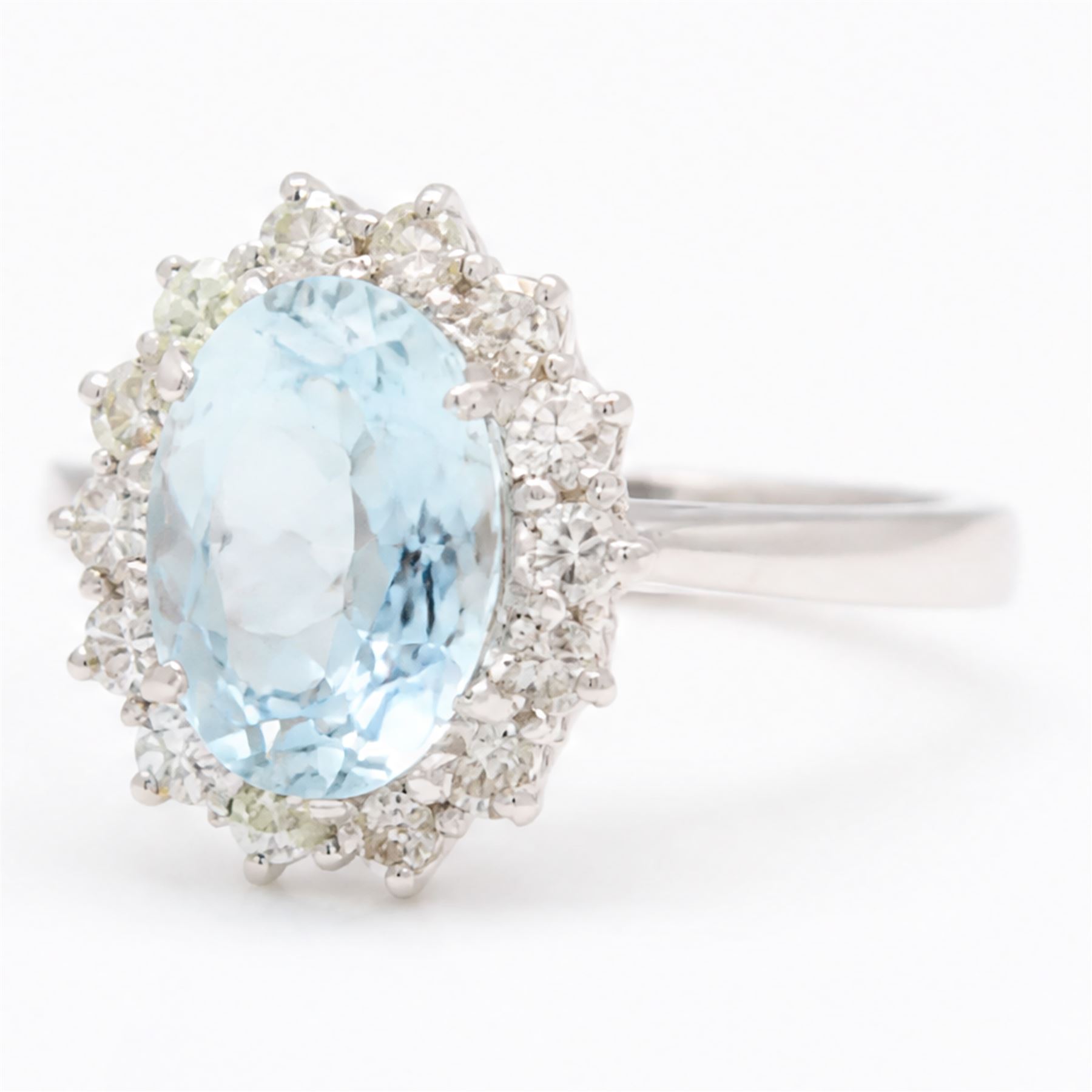 18ct white gold aquamarine and diamond cluster ring, single oval cut aquamarine of approx 1.95 carat, surrounded by fourteen round brilliant cut diamonds, London 2022, total diamond weight approx 0.50 carat