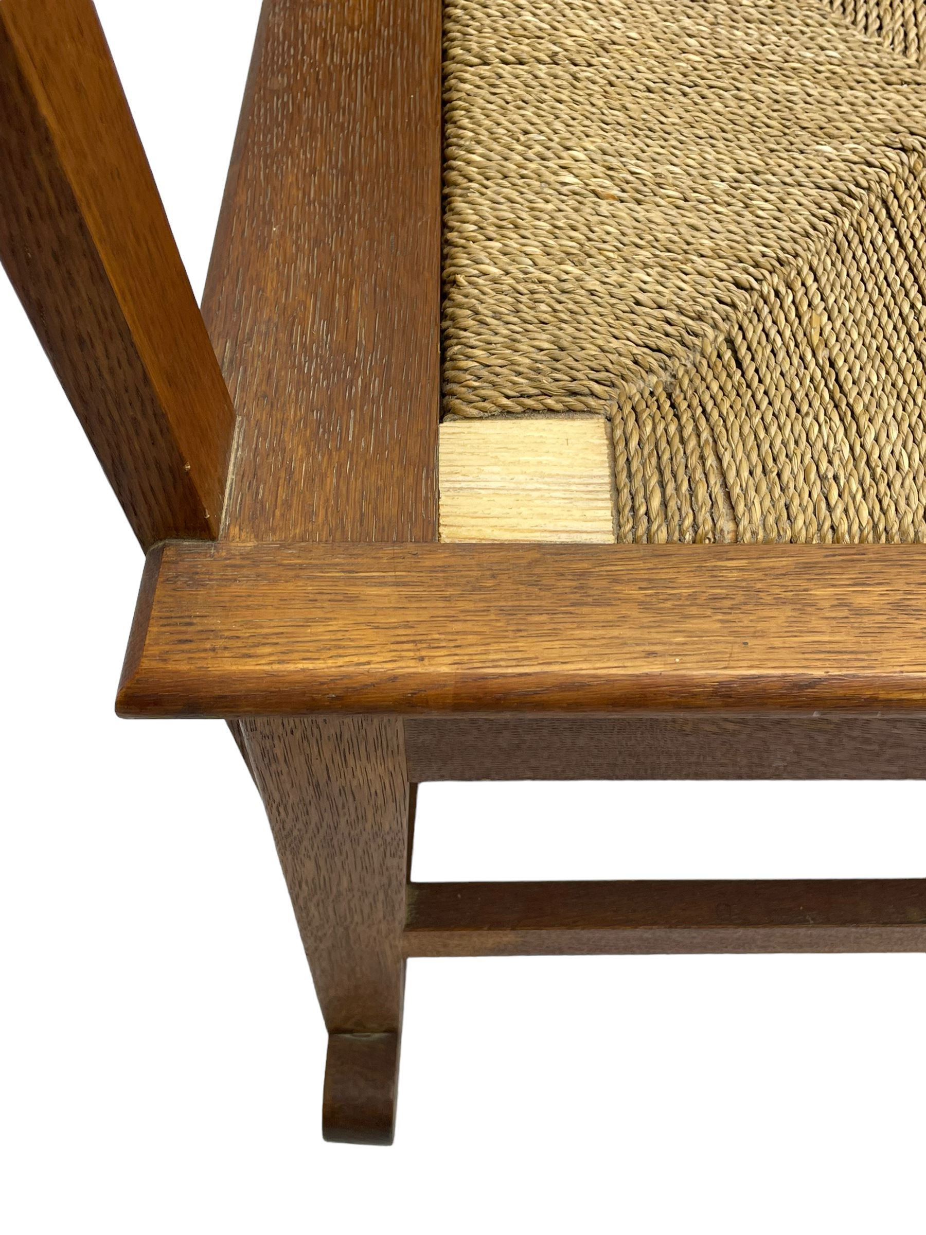 Reynold Eunson (1932–1978) for David Munro Kirkness, Kirkwall, Orkney - oak framed Orkney rocking chair, woven straw curved back, drop-in rush seat, the arm terminals with carved end scroll, on square tapering supports joined by plain stretchers, the front rail inscribed with makers marks