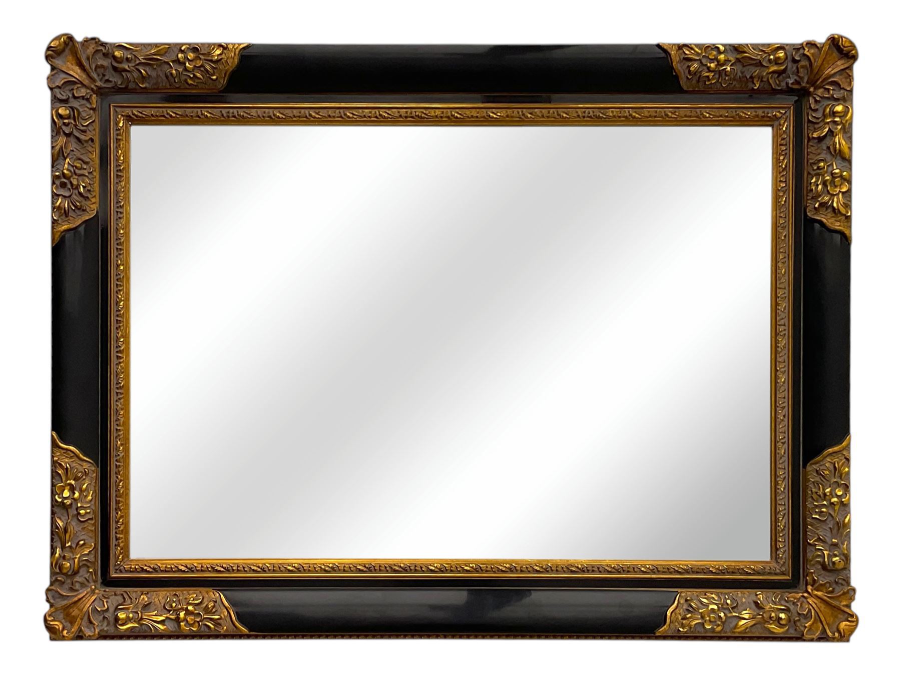 Early 20th century wall-hanging mirror, rectangular bevelled mirror plate within ebonised frame, gilt mounts to the corners carved with floral motifs 