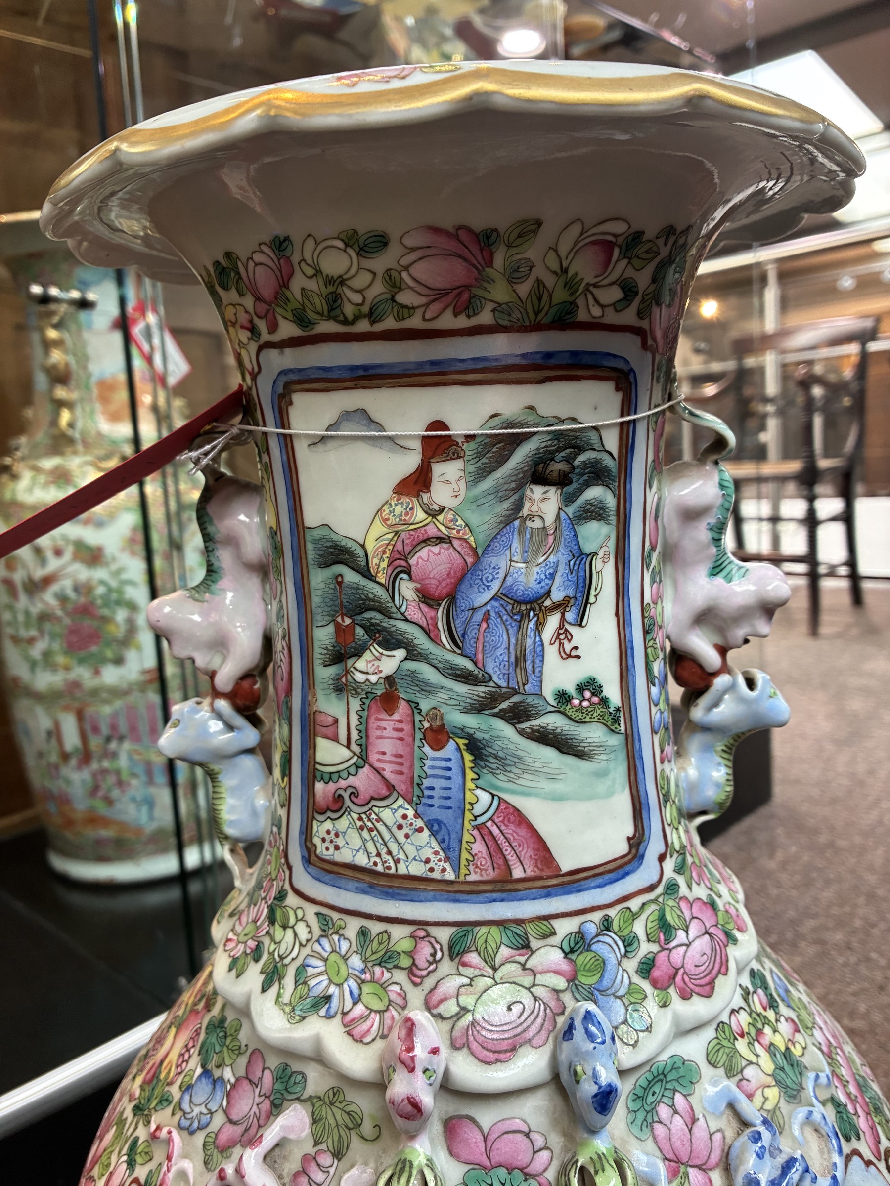 Large pair of 19th century Cantonese famille rose vases, each painted with various courtly scenes, including a display of warriors fighting on horseback before an official and his attendants, double Buddhist lion handles and applied at the shoulders with chilong, the lower band painted with Greek key motif, H58cm (2)