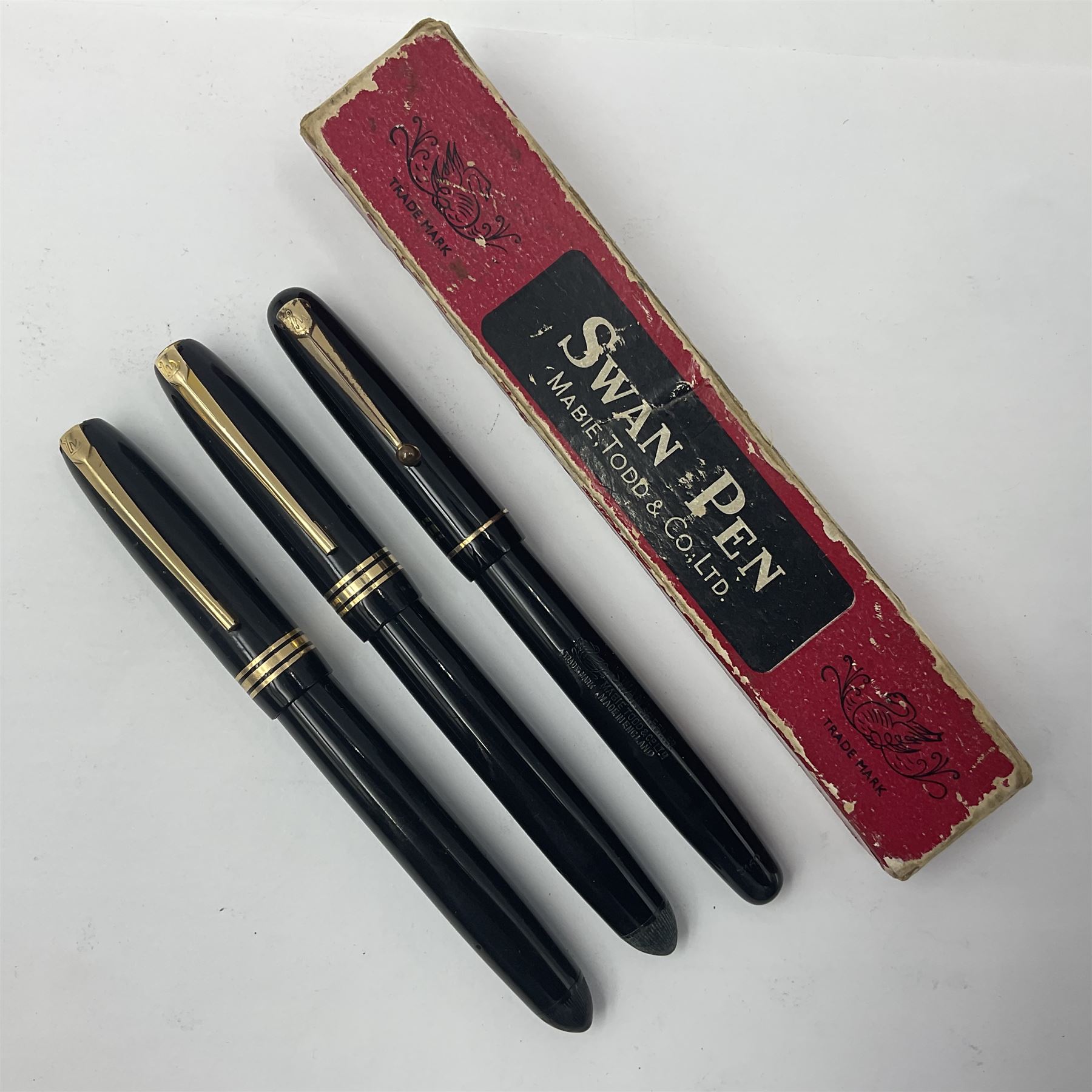 Three Swan Mabie Todd fountain pens, comprising Self Filler 3162 with black barrel and cap with single band and gold nib stamped Eternal 1 14ct, together with two Calligraph examples with gold nibs stamped 14ct, one with box, largest L12.5cm