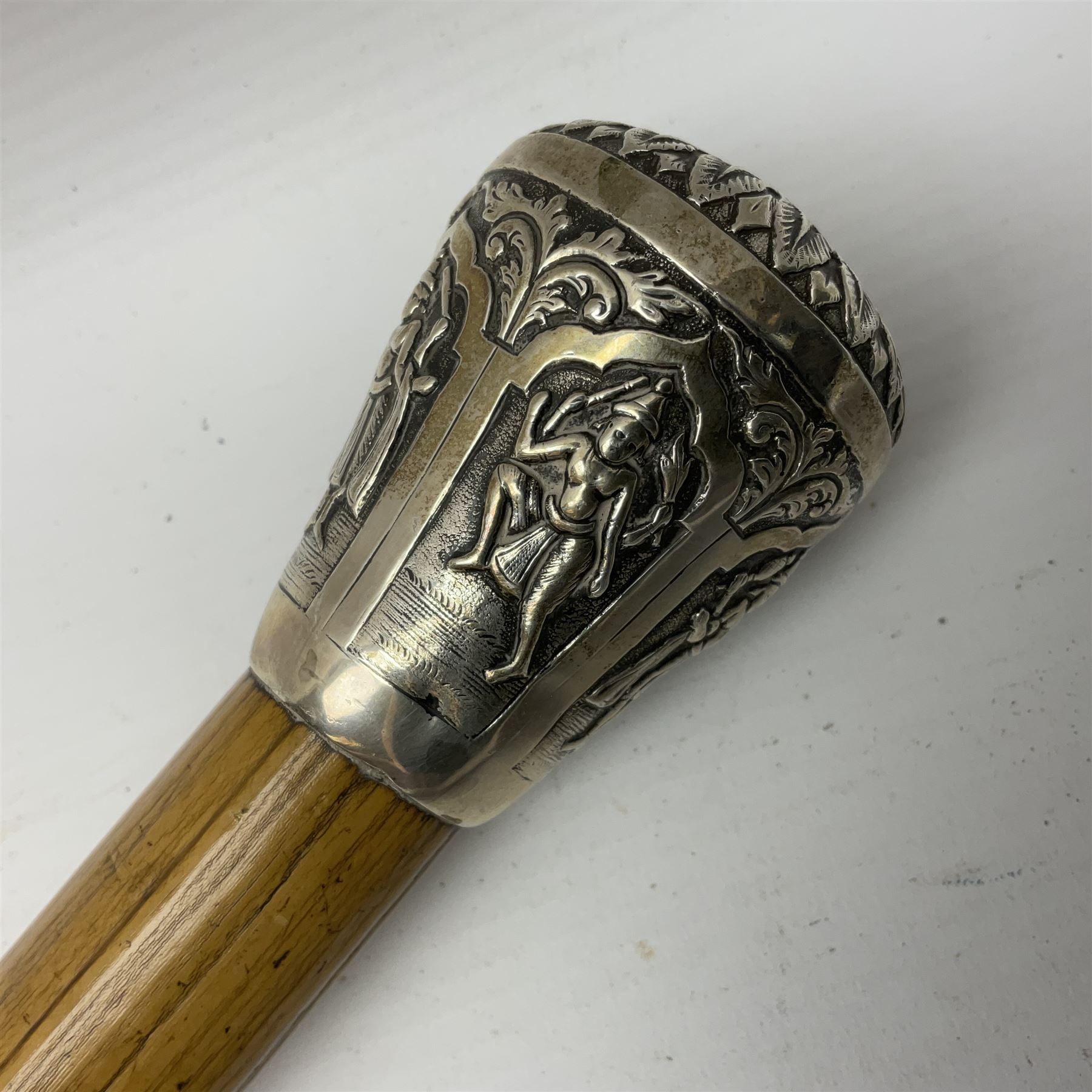 Malacca walking cane, with domed Burmese silver pommel embossed with deities, L91.5cm