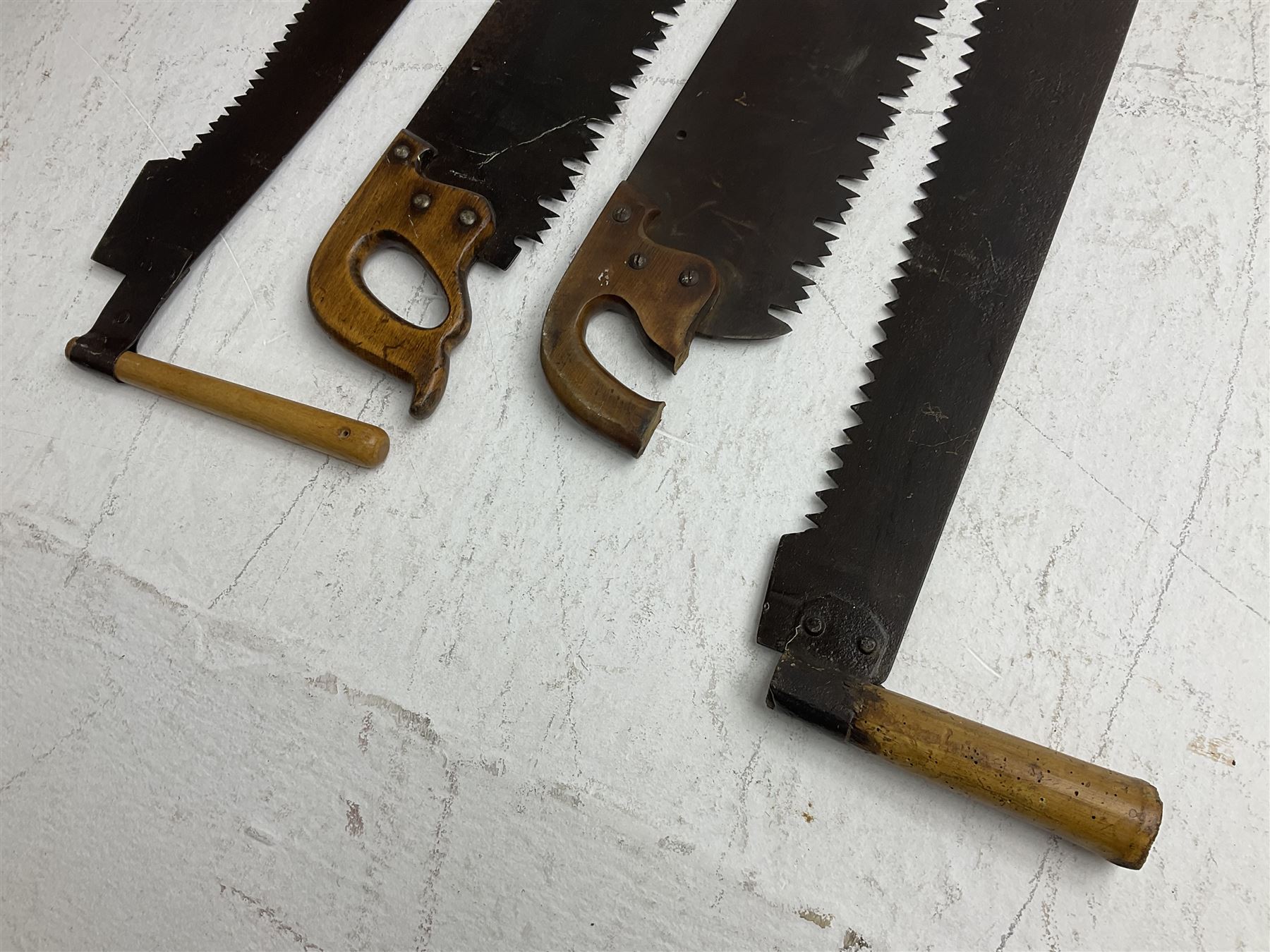 Four crosscut saws, comprising of three two handled examples and one