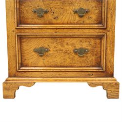 Small 20th century burr oak chest, the figured top over three graduated drawers with moulded fronts and pierced brass handles, on shaped feet