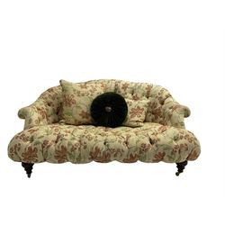 Victorian style two seat sofa, upholstered in beige ground floral floral pattern fabric, with scatter cushions, turned feet with brass castors