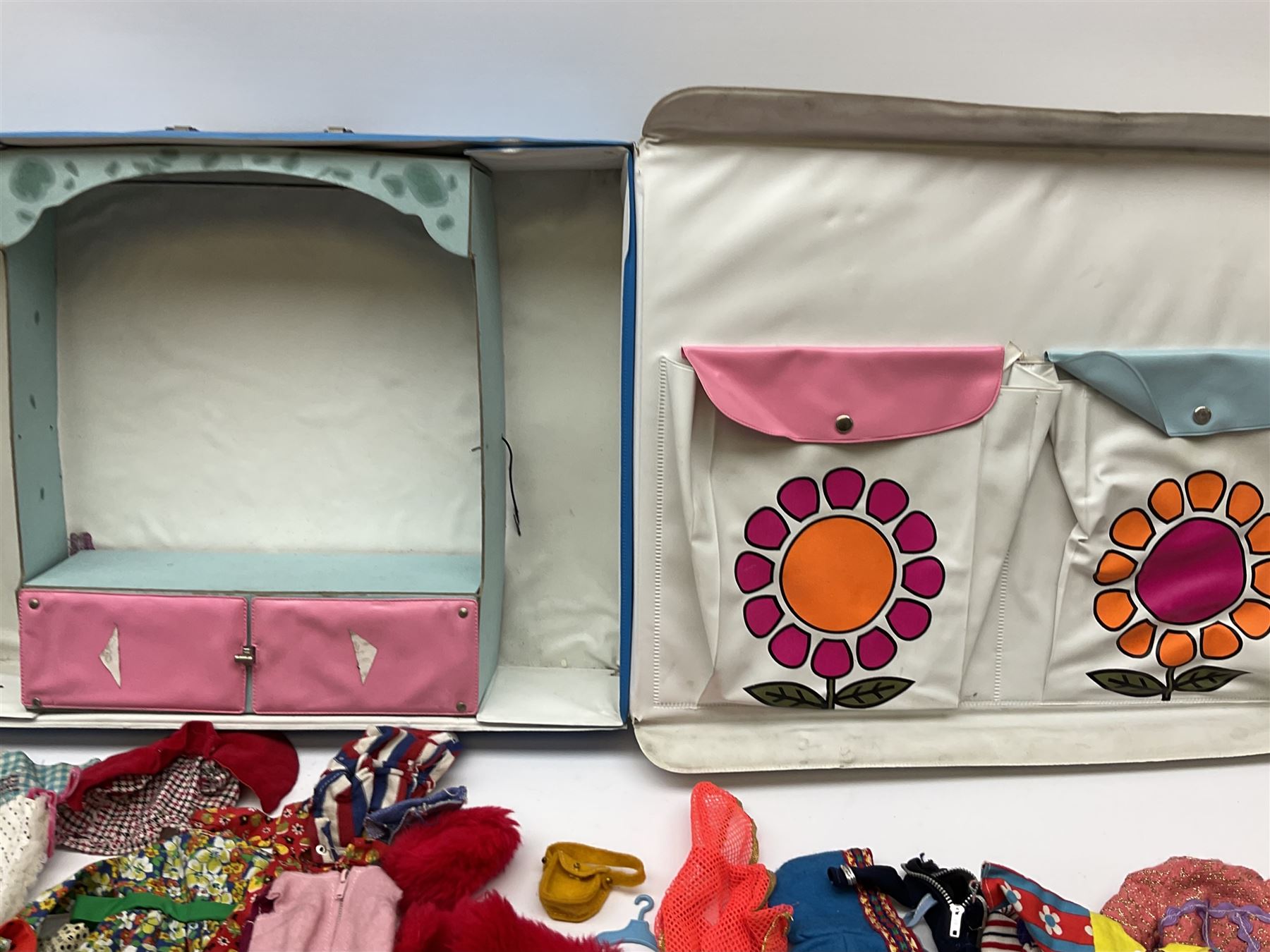 The World of Barbie Double Doll Case containing a quantity of assorted doll's clothing; together with two large and one small fashion dolls.