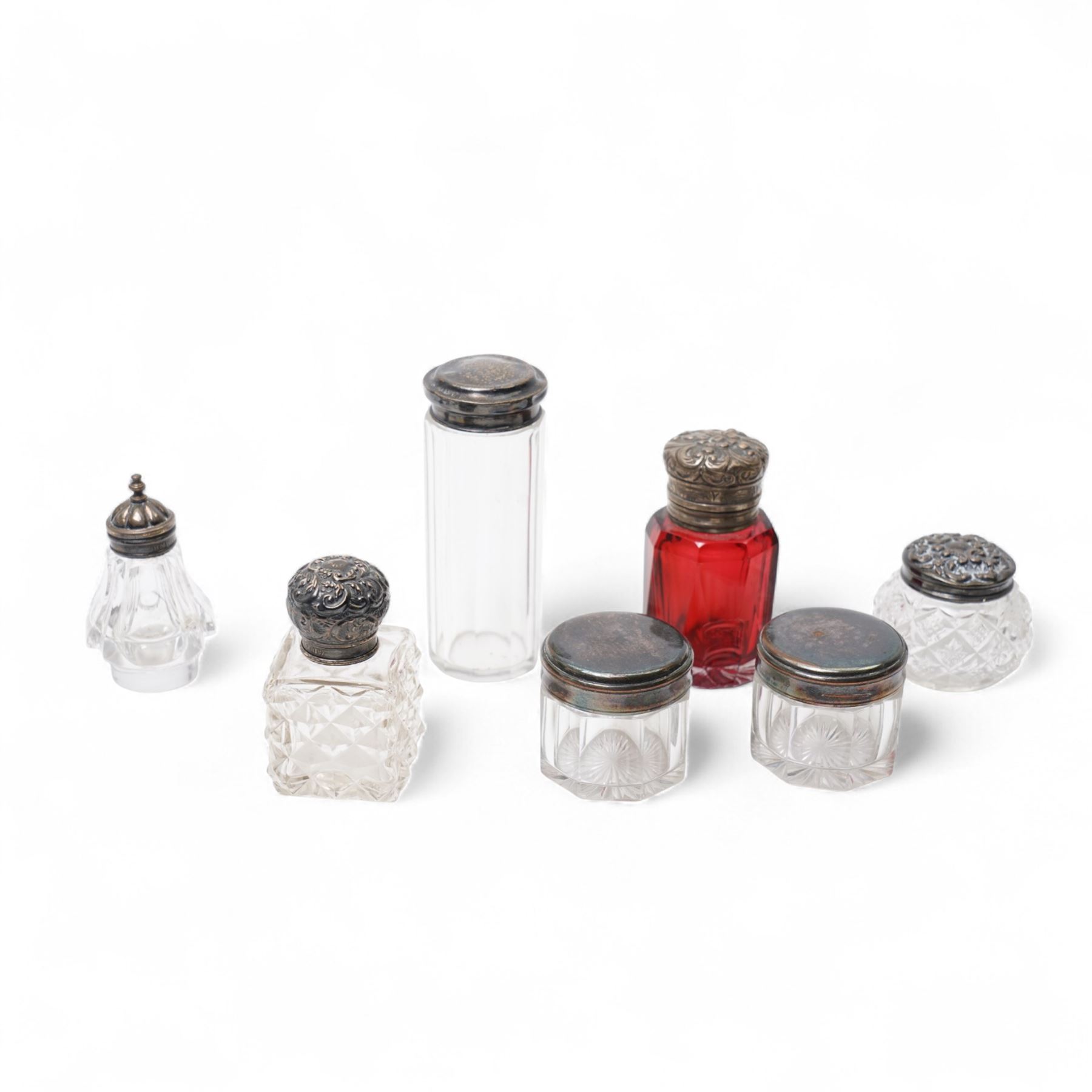Various silver topped glass dressing table jars, scent flask and a silver dressing table candlestick 