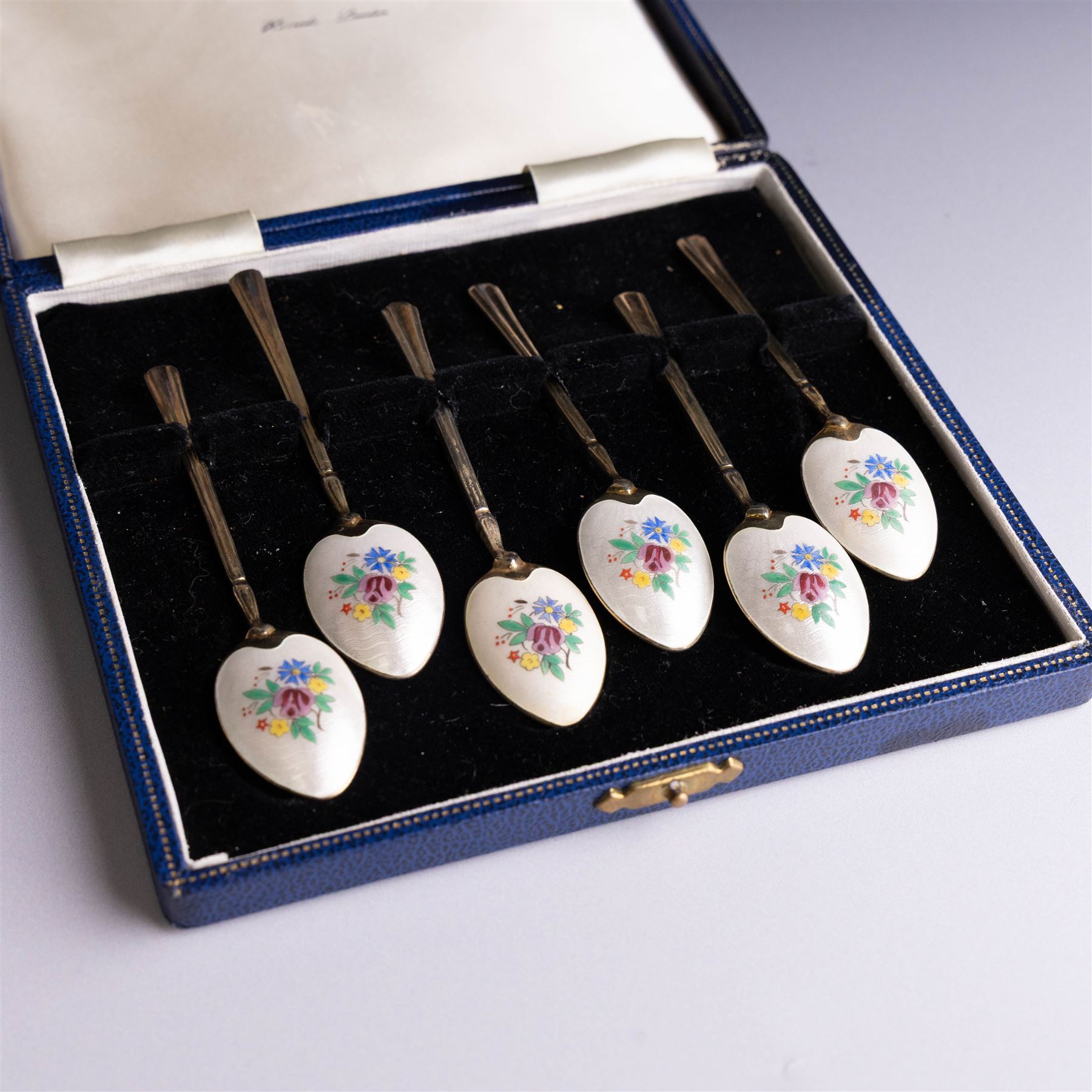 Set of six mid 20th century silver-gilt and guilloche enamel coffee spoons, the undersides of the bowls painted with colourful floral decoration, hallmarked Turner & Simpson Ltd, Birmingham 1960, within Harrods case