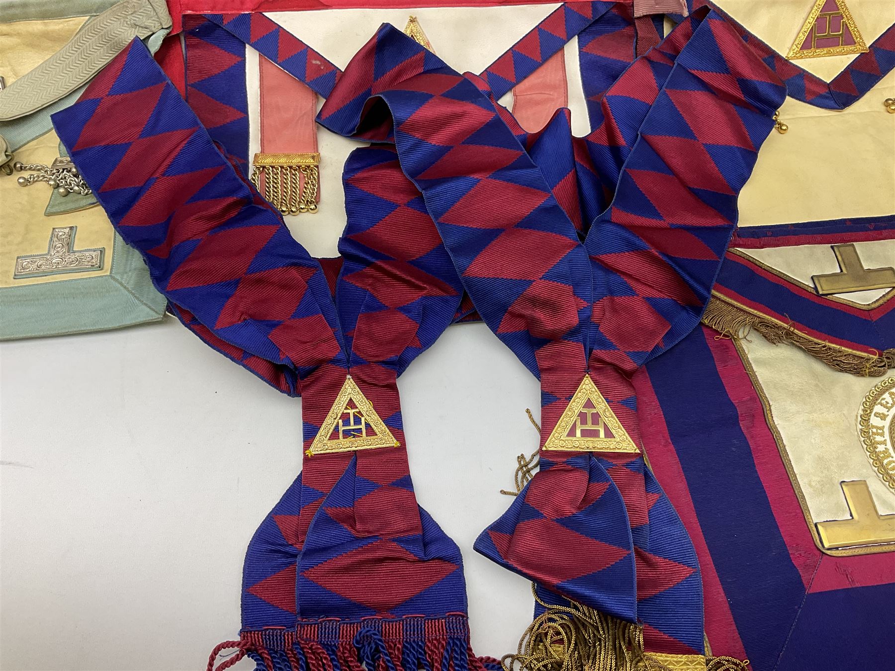 Two Masonic kid leather aprons, one with sash and cuffs, the other with sash, each marked 'Yorkshire North and East Ridings'; and three other unmarked Masonic aprons with sashes