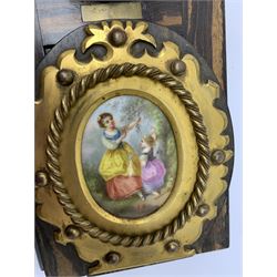 Victorian Betjemann's Patent coromandel book slide, the curved supports with shaped brass mounts enclosing hand painted porcelain panels depicting figures in garden settings, the hinges impressed Betjemann's Patent 11405, retracted L34cm 