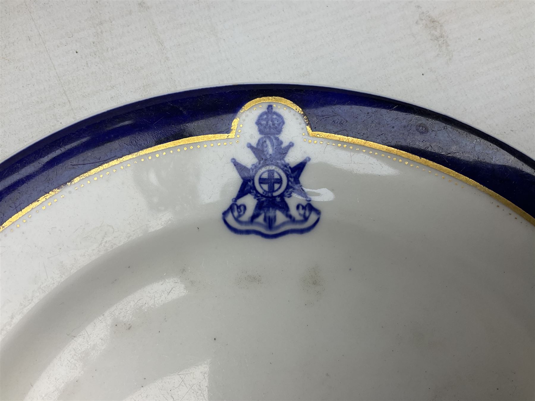 Collection of Regimental dinner wares, Comprising Royal Sussex; two dinner plates, two side plates and a soup bowl, Royal Leicestershire; two dinner plates, East Yorkshire Regiment side plate and Gordon Highlanders side plate, all decorated with the regiment's crests and blue and gilt boarders (9)