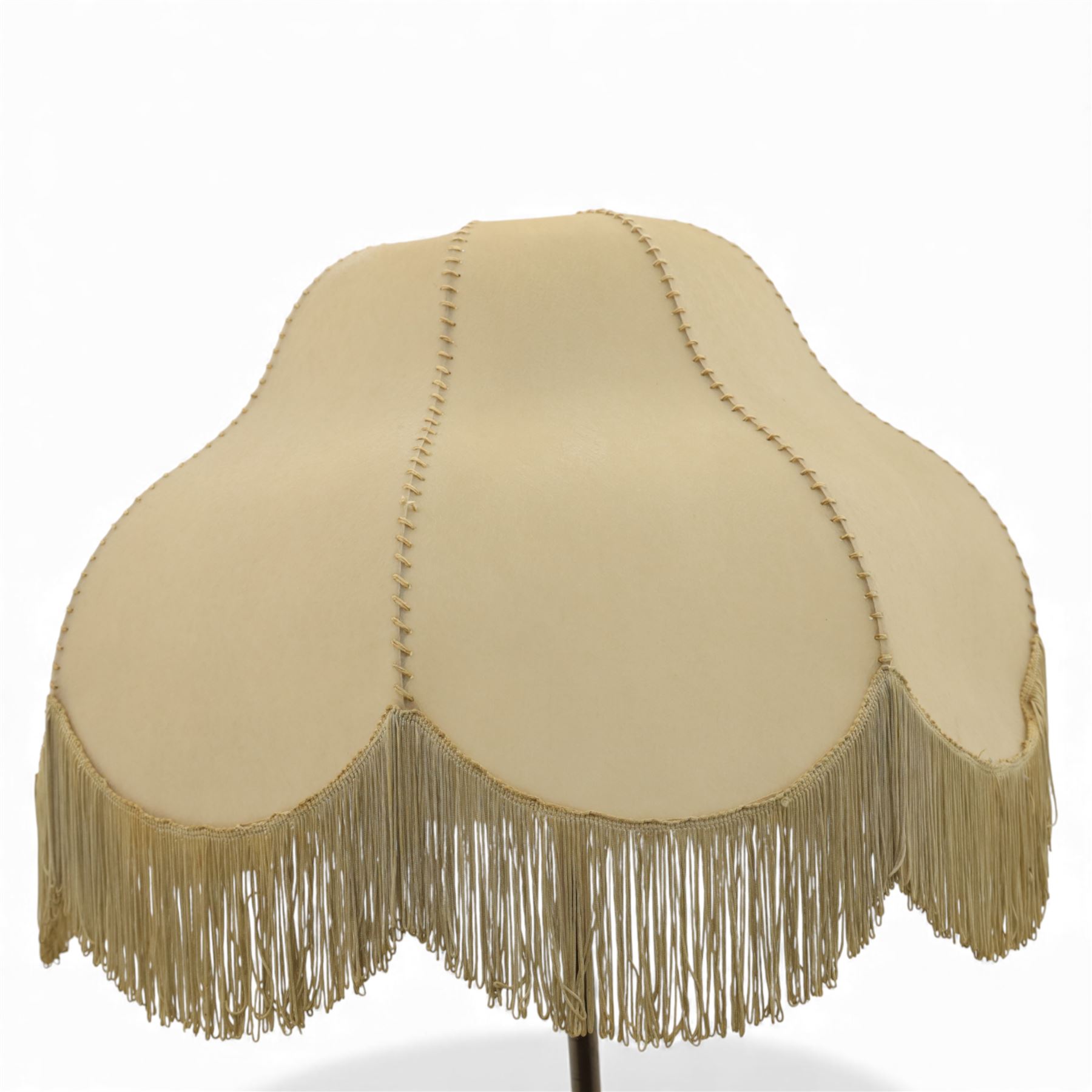 Early 20th century Art Nouveau metal standard lamp, the slender column with adjustable collar, raised on a circular dished base with three pad feet, fitted with a metal gallery and bulb holder, beige raw hide with fringe 