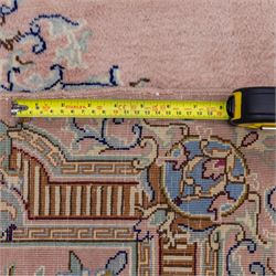 South East Persian Kirman hand-knotted rug, pale blush field with central scalloped medallion within an elaborate scalloped cartouche, spandrels filled with fine scrolling vine-work, palmettes and floral sprays, enclosed by wide and narrow borders in soft tones of blush pink, ivory, powder blue, sage green and pale gold, with cotton fringe ends 