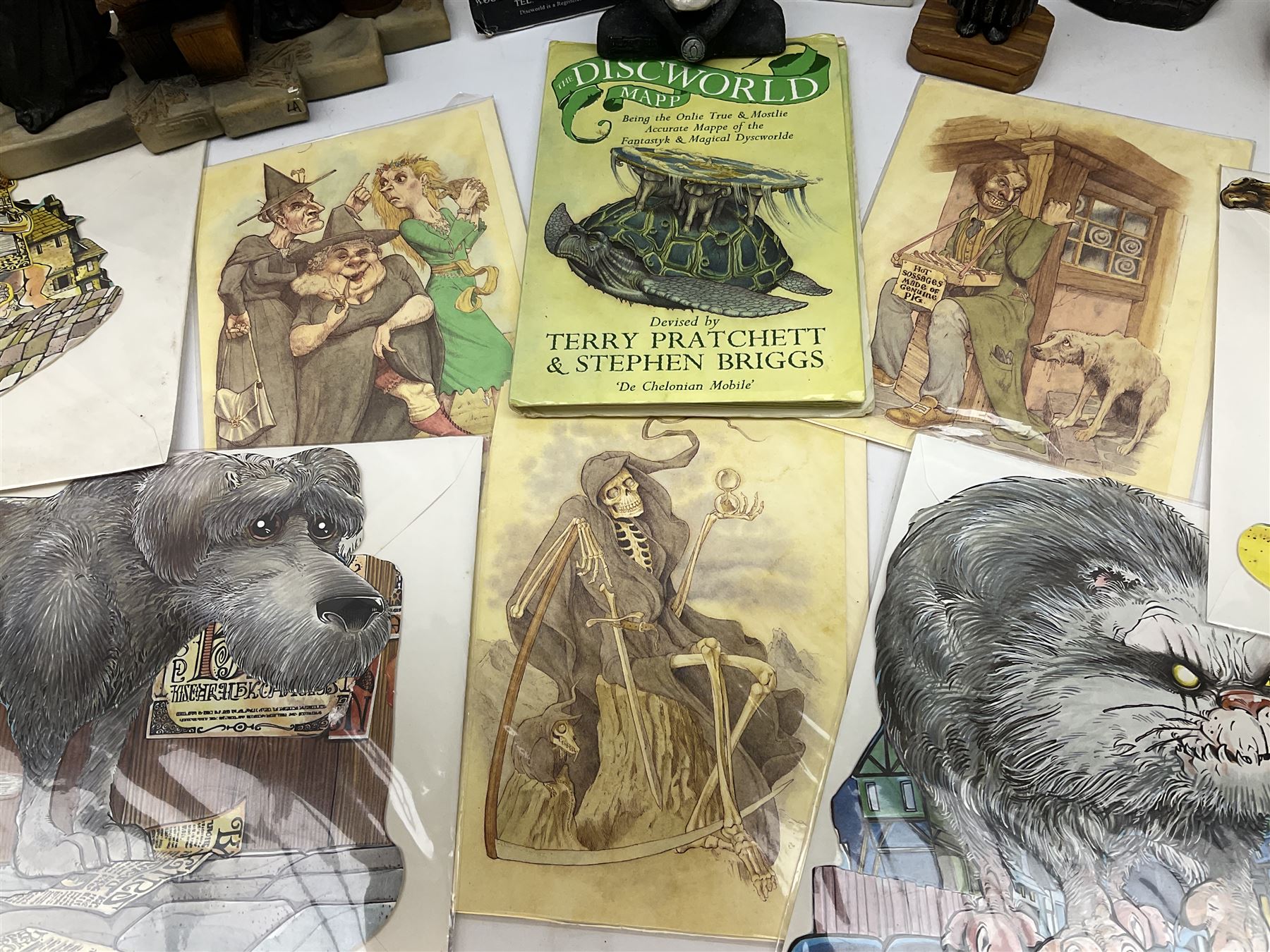 Terry Pratchett Discworld figures, designed by Clarecraft, comprising Death and Granny Weatherwax, DW90, Deathhead DWE8, Dried-frog pill box, boxed, DW63, Death as Beau Nidle, boxed, DW88, Agnes Nitt DW68, Detritus, DW22, Bonsai mountain, DW78, Volcanic bonsai mountain, boxed, DW79, Bonsai mountain valley, DW80, together with the Discworld mapp, and a collection of Terry Pratchett cards.  